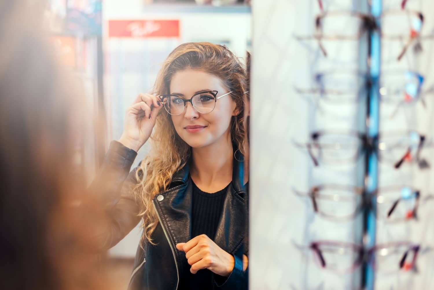 Woman trying on new glasses in an optical shop